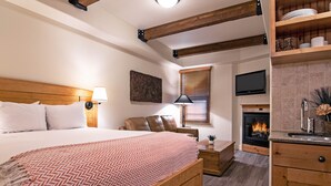 Un dormitorio con cama, mesita de noche, lámpara y chimenea.