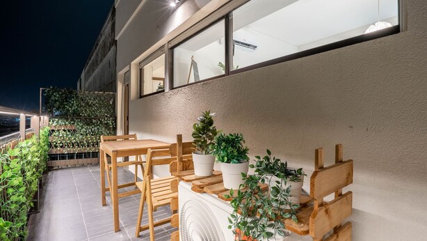 An outdoor patio with wooden furniture and potted plants. - Porto Heights by LovelyStay (Porto)