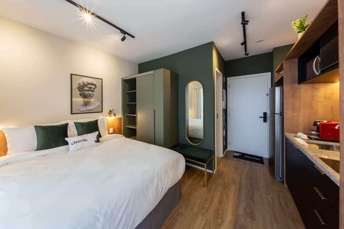 A modern bedroom with a bed, bedside table, and a wardrobe.