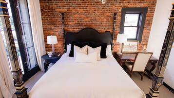 A bedroom with a large bed, a desk, and a chair.