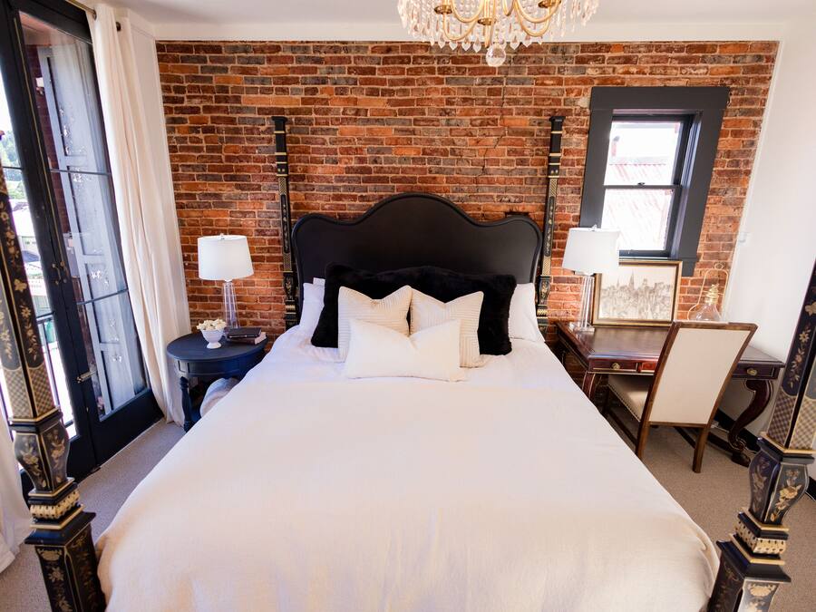 A bedroom with a large bed, a desk, and a chair.