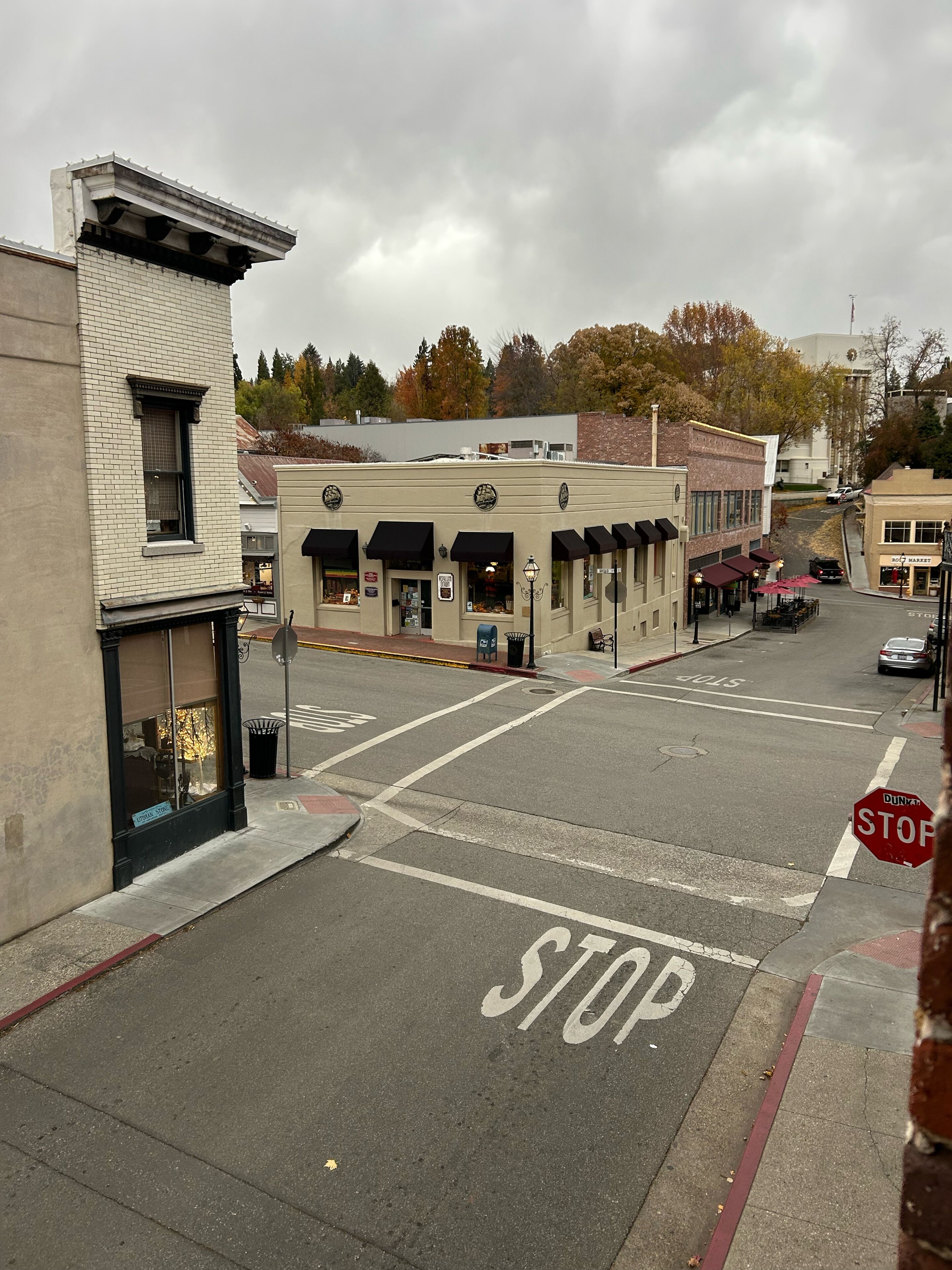 A street view with a STOP sign, buildings, and a sidewalk.