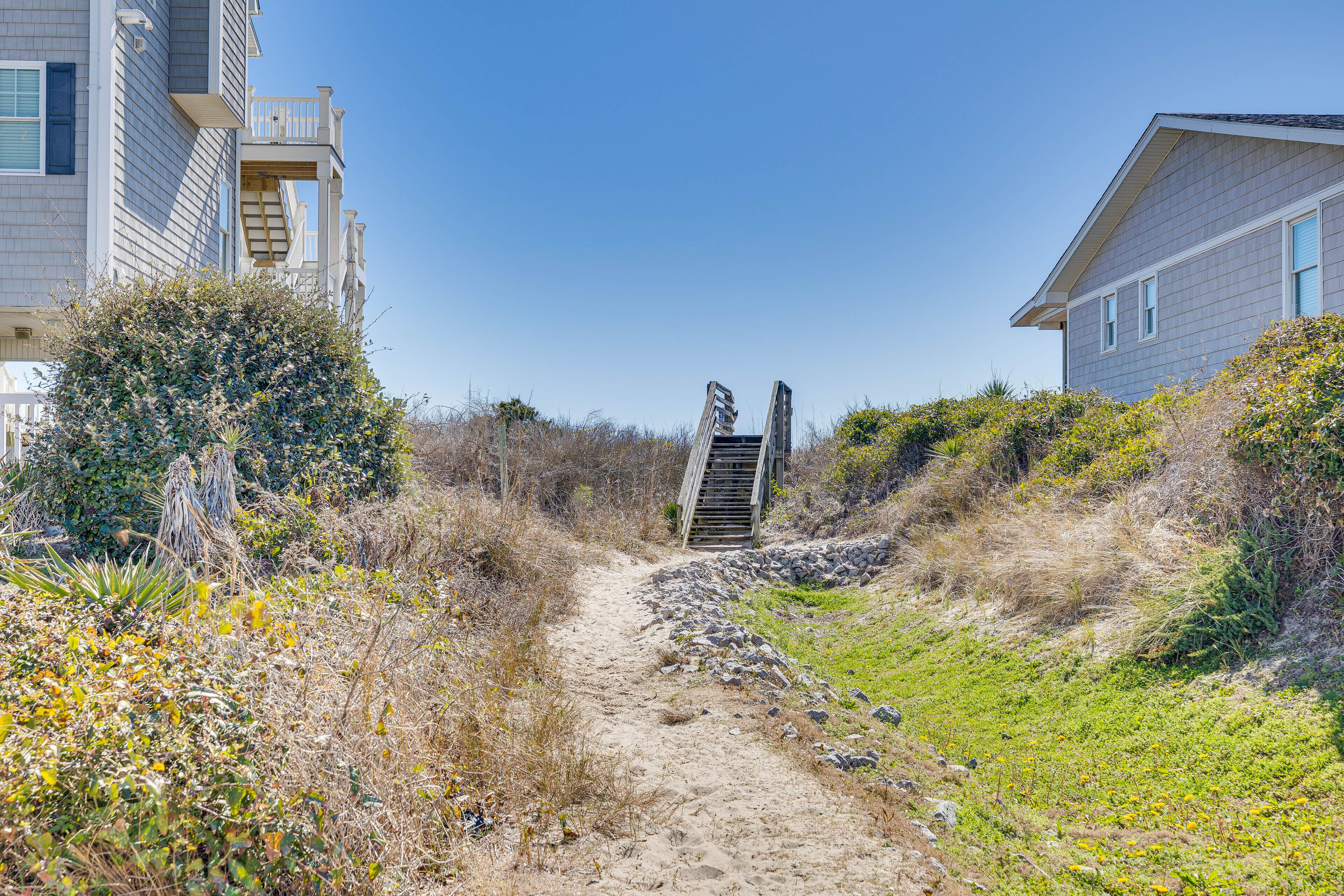 Un chemin menant à un escalier, avec un bâtiment sur la gauche et un autre sur la droite.