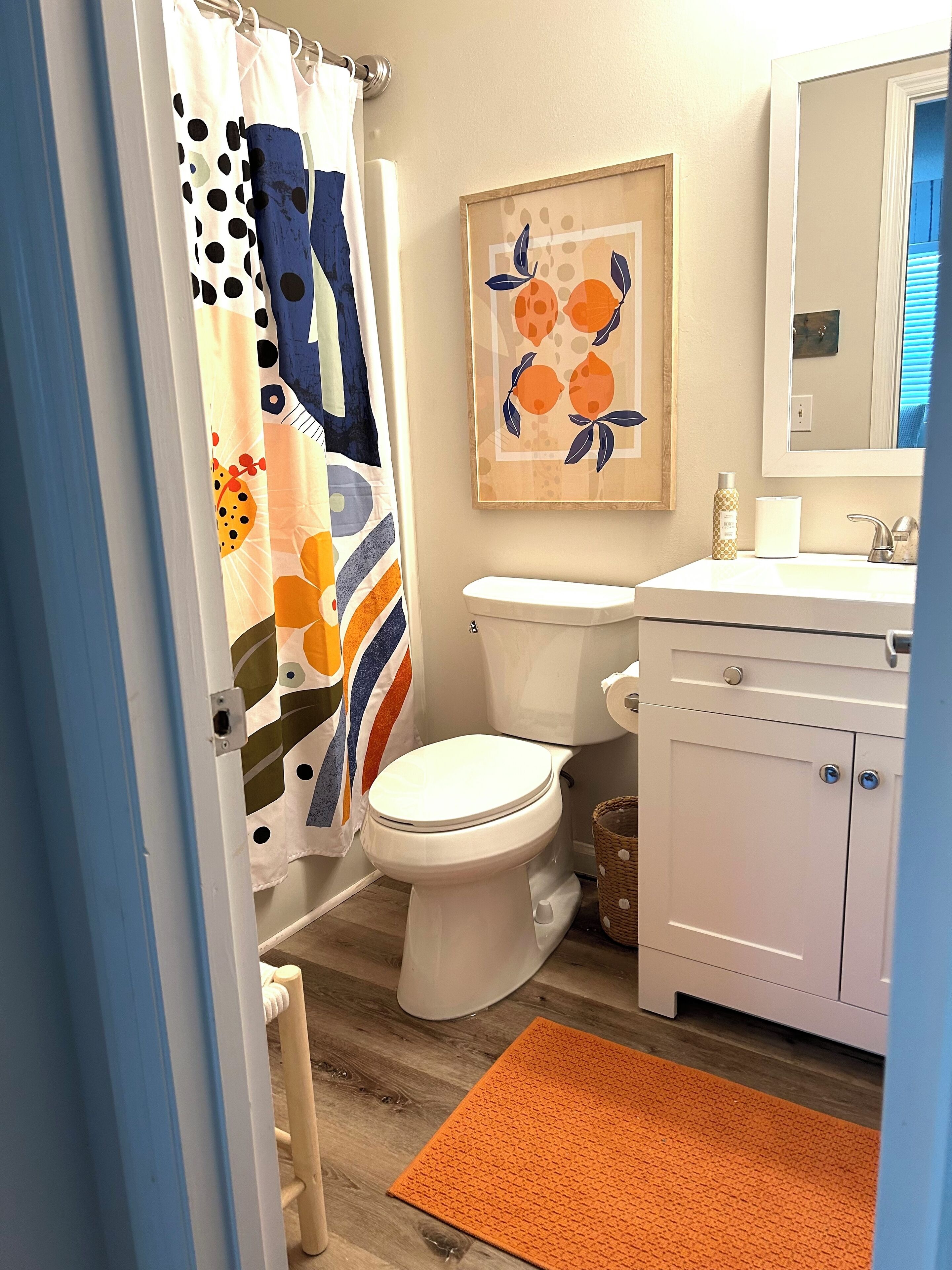 Une salle de bain avec des toilettes, un lavabo et un rideau de douche.