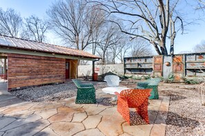 A rustic cabin with a metal roof, surrounded by a patio with stone flooring and outdoor furniture. - 2 Mi to UA: Central Fayetteville Home w/ Patios (Fayetteville)