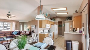 A spacious living area with a dining table, chairs, a sofa, and a ceiling fan. - Cozy Lake Havasu City Home - Pool and Hot Tub (Lake Havasu City)