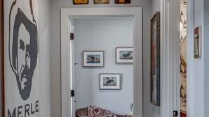 A hallway with a wooden ceiling, a door with the number 307, and a patterned armchair.