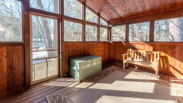 A wooden cabin with large windows, a bench, and a green chest. - Wooded setting, close to town, clean! ATV & snowmobile from front door! (Ely)