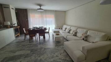 A living room with a dining area, a sofa set, and a fireplace.