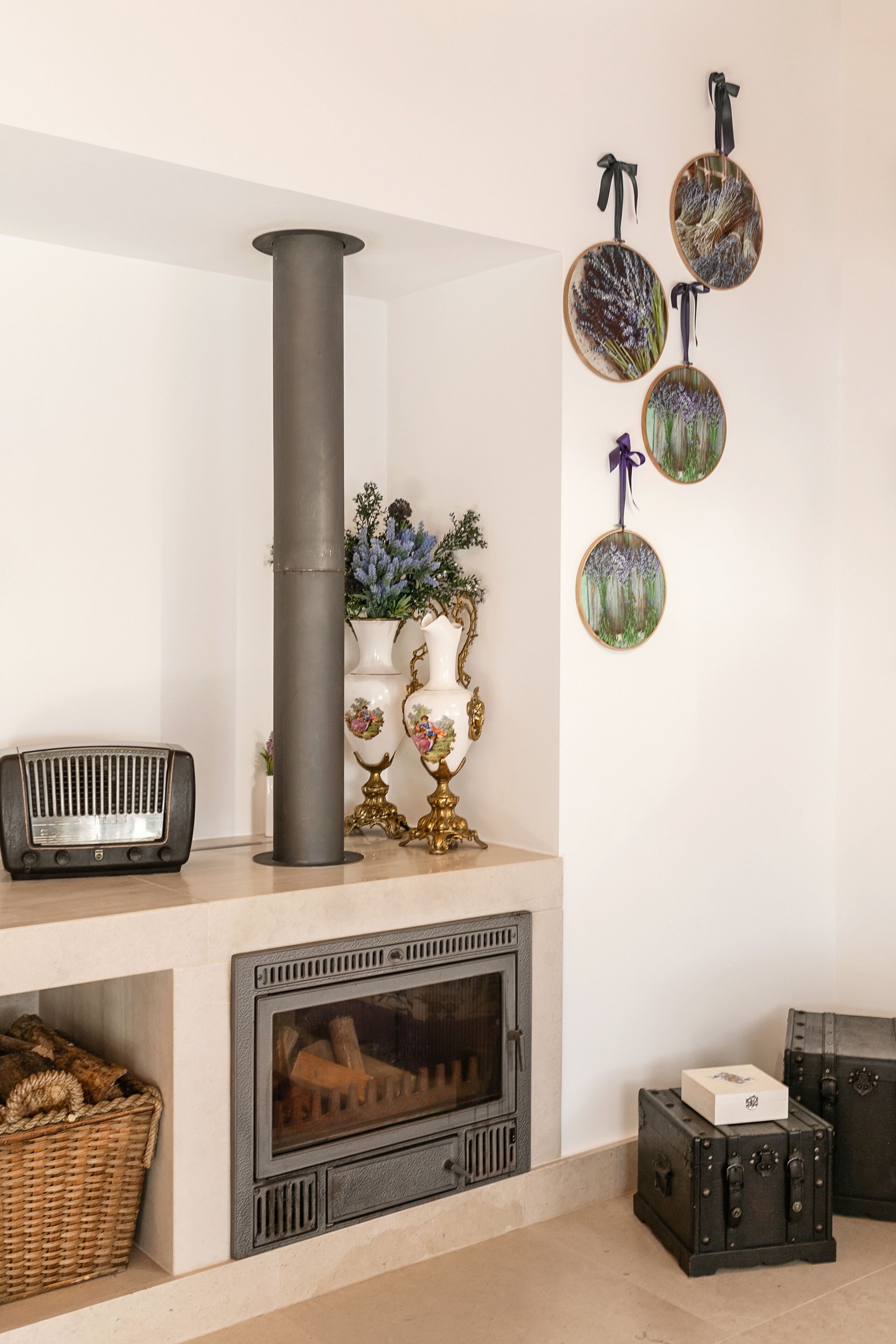 A living room with a fireplace, decorative vases, and a radio.