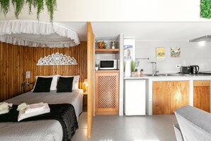 Ein kleines Hotelzimmer mit Bett, einer Kochnische und einem Badezimmer.