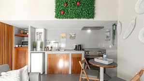 Een moderne keuken met een inbouwkoelkast, een fornuis en een eethoek met een kleine tafel en stoelen.