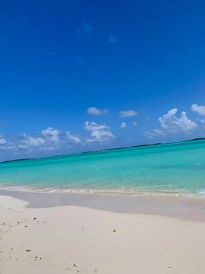 A beach with clear turquoise water and a white sandy shore.