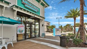 A Bahama's Original Shaved Ice Company storefront with a clear entrance, outdoor seating, and a directory sign.