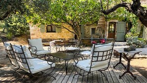 An outdoor patio with metal furniture and a stone building in the background.