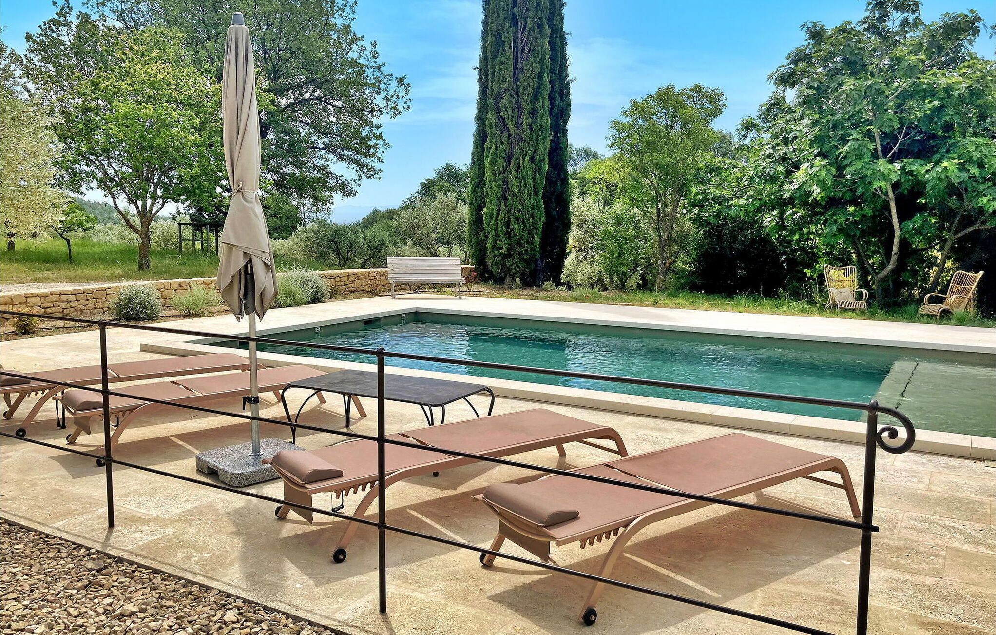 A poolside area with lounge chairs and a covered umbrella.