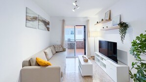 Ein modernes Wohnzimmer mit einer Couch, einem Fernseher und Kunstwerken an den Wänden.