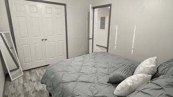 Une chambre à coucher avec un lit, un ventilateur de plafond et une porte.