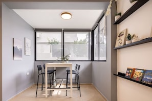 A room with a table and chairs, large windows, and shelves with books. - Serenity by the Sea – Poleg Villa (Netanya)
