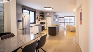 A modern kitchen with a dining area, a small island, and a view to the living room.