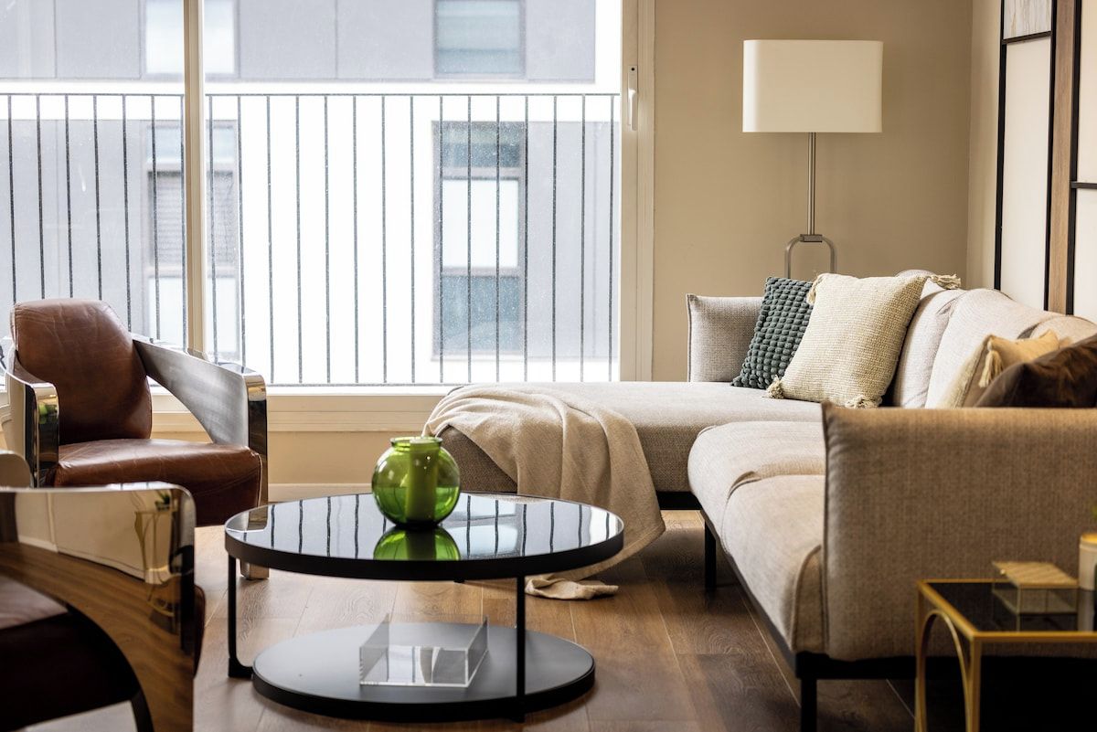 A modern living room with a sofa, a coffee table, and a lamp.