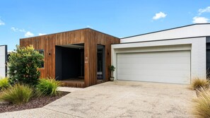 A modern two-story house with a wooden exterior and a white garage door.
