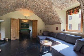 A cozy living room with a curved ceiling, a sofa, a coffee table, and a painting on the wall. - Villa Oasi - My Home in Como (Canzo)