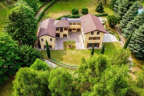 A large, two-story building with a symmetrical facade, a central courtyard, and a well-maintained lawn. - Villa Oasi - My Home in Como (Canzo)