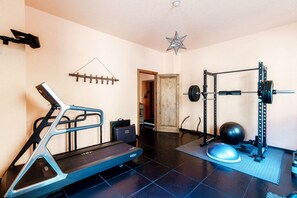 A home gym with a treadmill, weight bench, barbell, and exercise balls. - Villa Oasi - My Home in Como (Canzo)