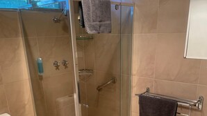 A modern bathroom with a glass-enclosed shower, a toilet, and a towel rack. - CABIN 2Q - Couple or single, motel style cabin (Thornton)