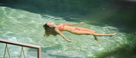A person floating in a clear pool.