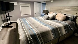 Une chambre à coucher avec un lit, une lampe, un téléviseur et une porte.