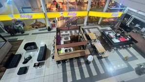 Ett stort inomhusutrymme med flera nivåer, ett centralt område med sittplatser, en kiosk där man kan köpa mat och dryck samt en restaurang som är väl synlig.