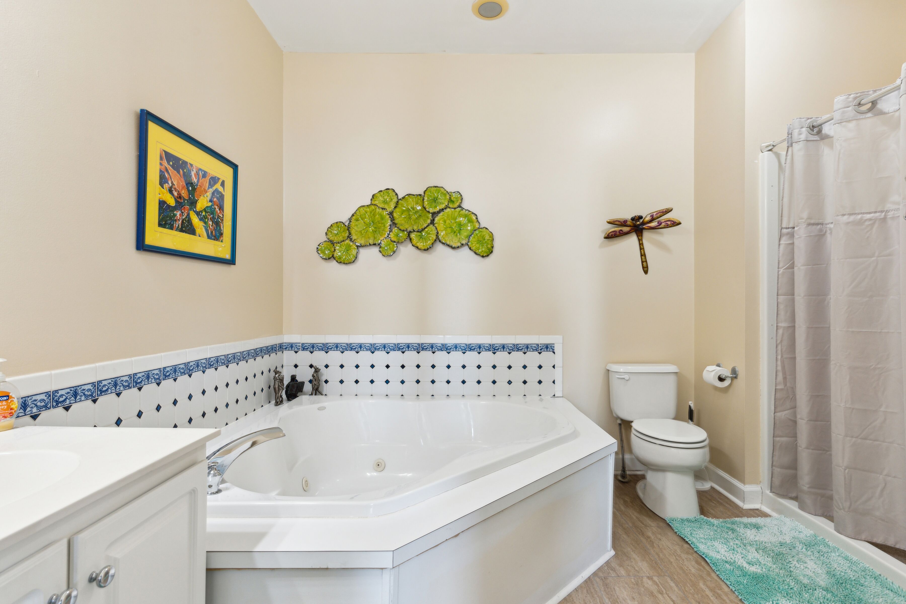 A bathroom with a bathtub, toilet, and shower curtain.