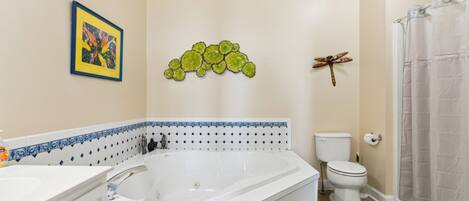 A bathroom with a bathtub, toilet, and shower curtain.