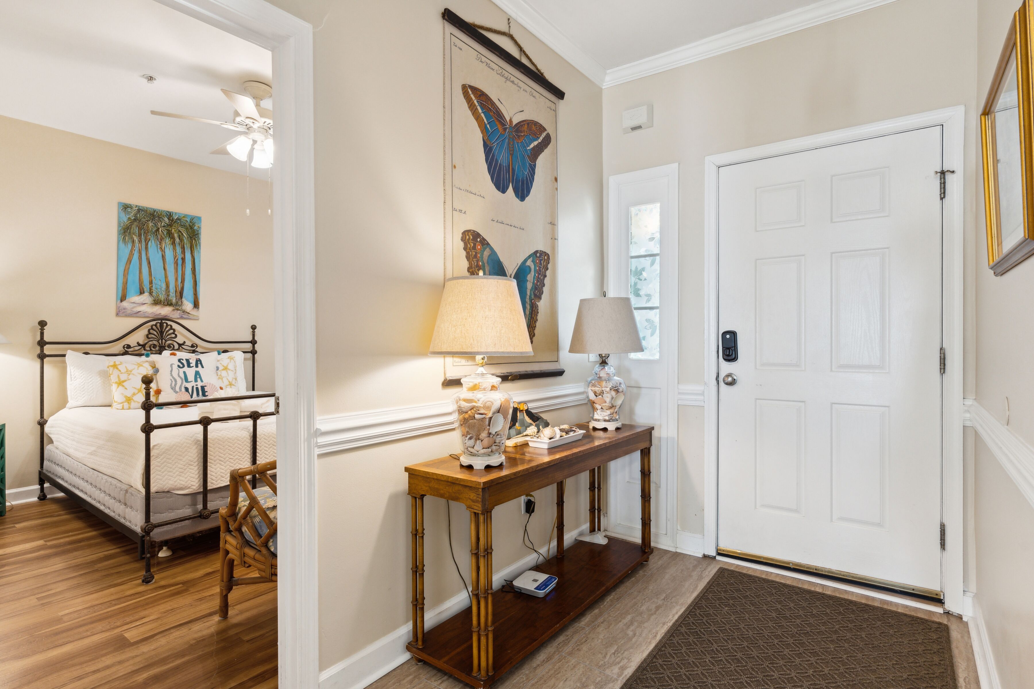 A bedroom with a bed, bedside table, lamp, and a wall-mounted painting.