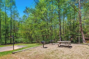 Un parc équipé d’un terrain de basket, d’une table de pique-nique et d’une boîte aux lettres.