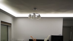 Een woonkamer met een bank, een salontafel, een televisie en een boekenkast.