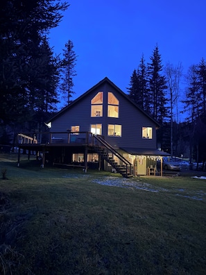 Une maison à deux étages avec une grande véranda à l’avant, un escalier menant à l’étage supérieur et un garage.