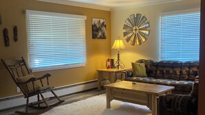 A living room with a rocking chair, a sofa, a coffee table, and a lamp. - Blocks from downtown and has that country feel. Nestle in Columbia Falls comfort (Columbia Falls)