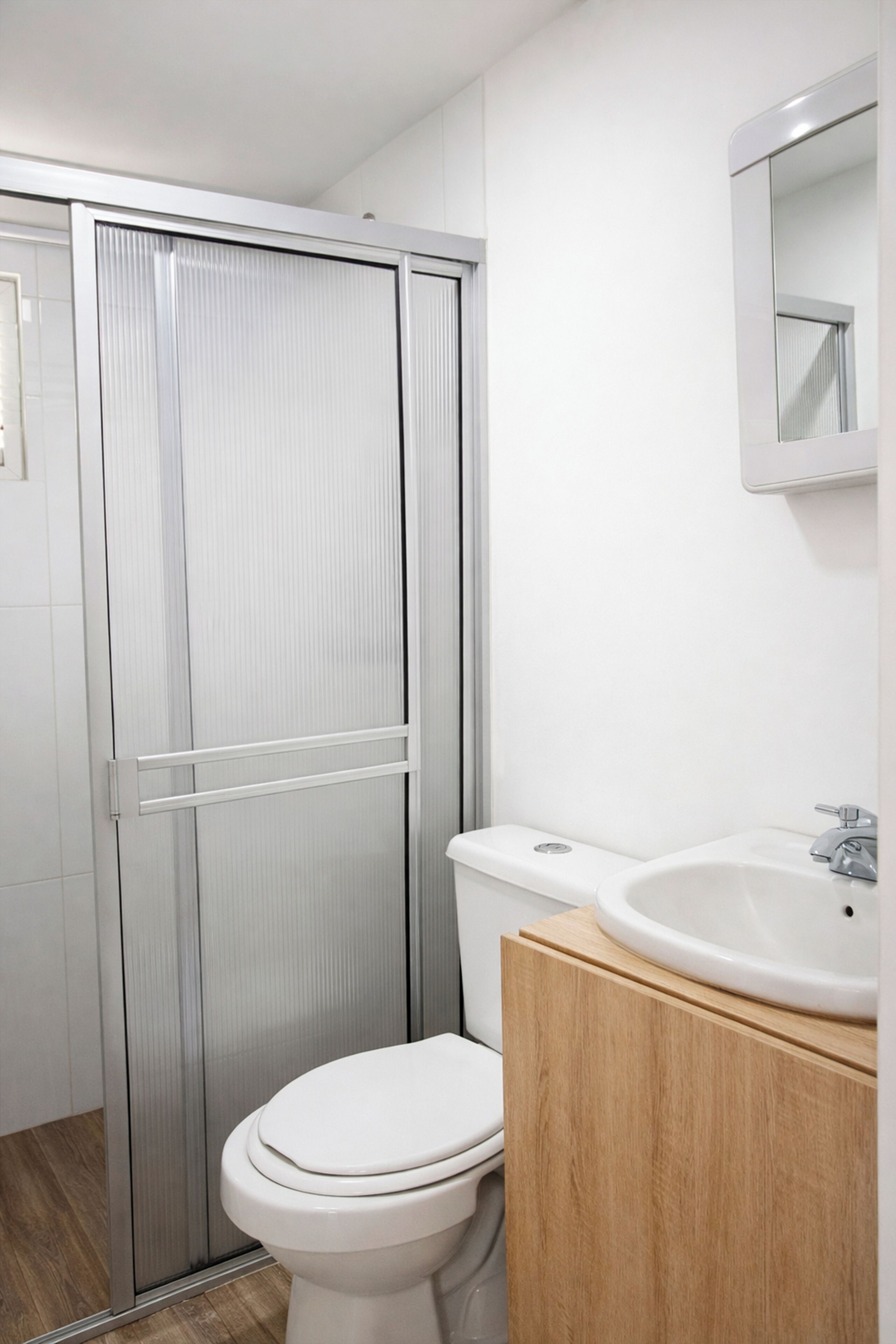 A bathroom with a toilet, a sink, and a mirror.