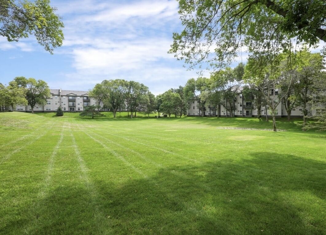 A grassy courtyard with a building in the background.