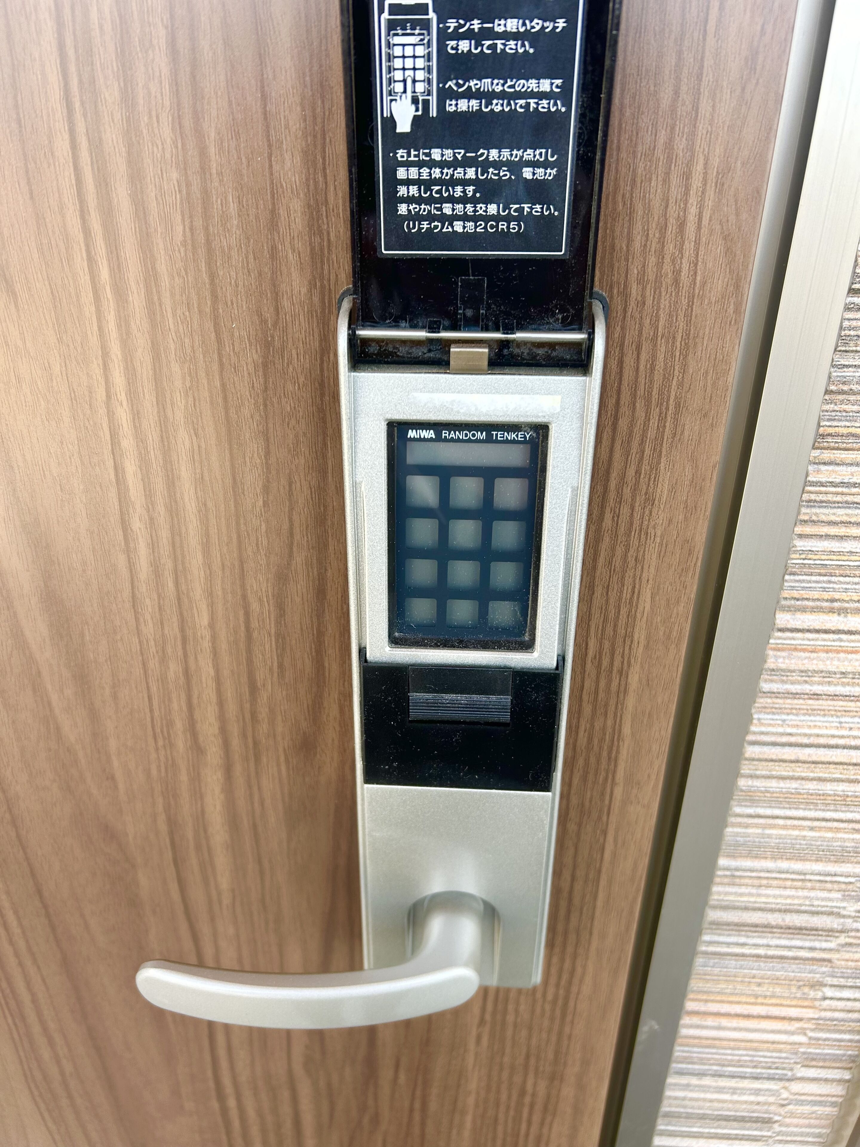 Une porte dotée d’un clavier et d’un lecteur de carte, probablement pour un système de contrôle d’accès des chambres d’hôtel.