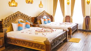A hotel room with two ornate beds, each with a wooden headboard and white bedding. - Puok hotel & Resort (Puok)