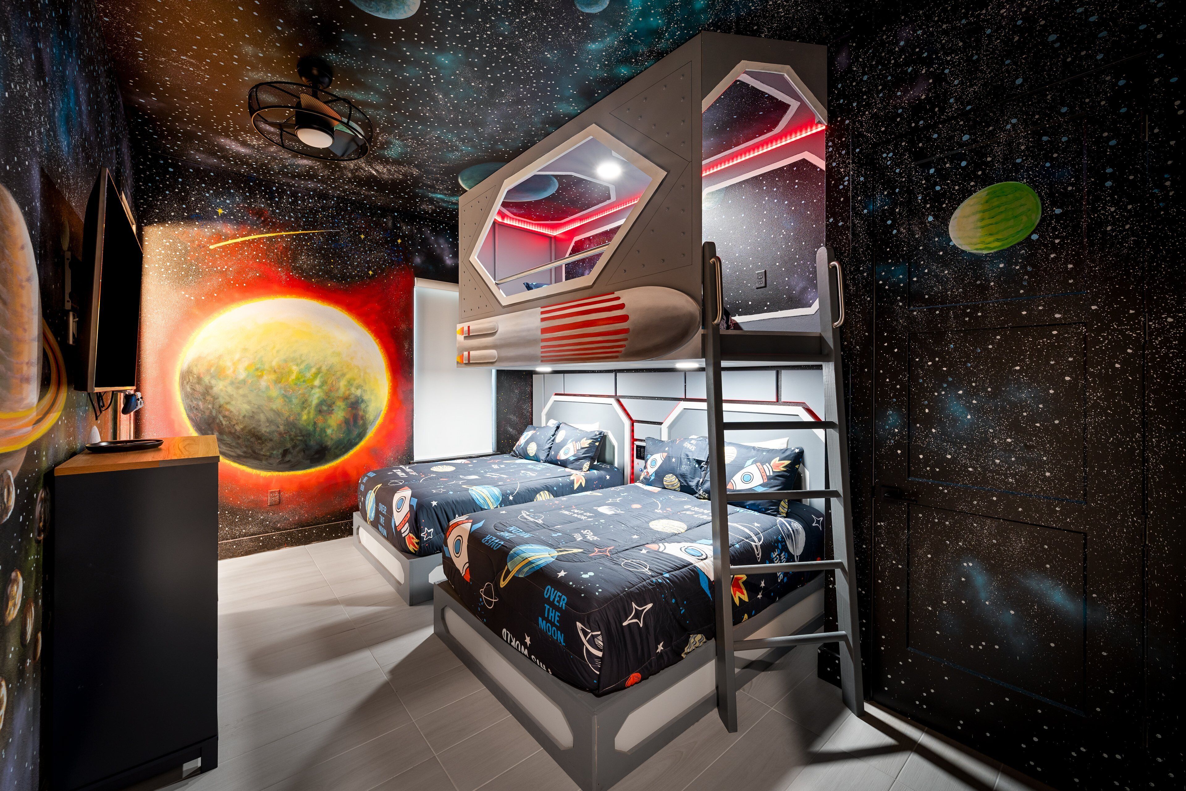 A bedroom with a bunk bed, a space-themed mural, and a telescope.