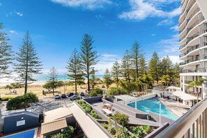 Ein Resort mit Pool, Blick auf den Strand und mehreren Balkonen.