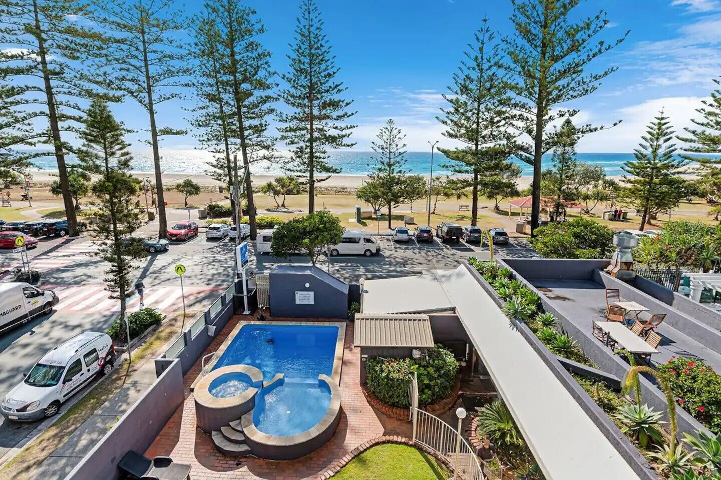 A rooftop pool area with a view of the beach and ocean.