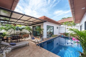 Una piscina al aire libre, sillones reclinables de piscina