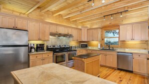 Una cocina moderna con armarios de madera, electrodomésticos de acero inoxidable y una isla grande.