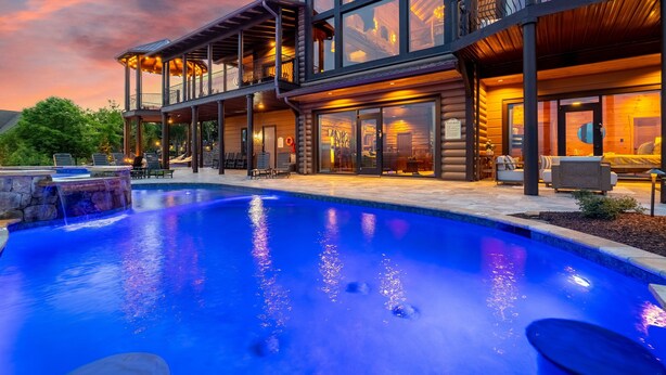 A modern two-story building with a swimming pool, outdoor seating, and a covered patio area. - Fine As Wine ~ Resort Pool, Swim-Up Bar, Pickleball, Putt-Putt & Epic Views (Sevierville)